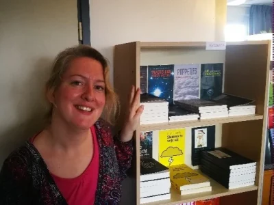 Nanneke naast een boekenkast bij Tobi Vroegh.
